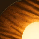 Close-up of a textured surface with a light source creating a warm glow.
