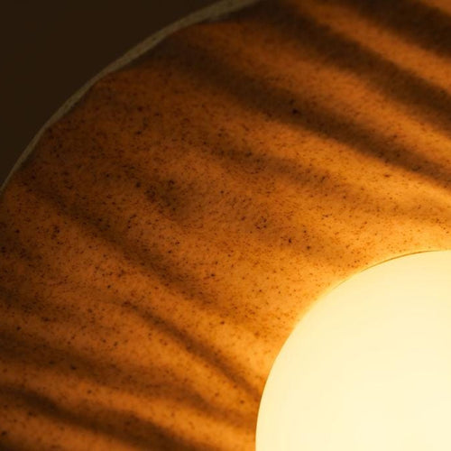Close-up of a textured surface with a light source creating a warm glow.