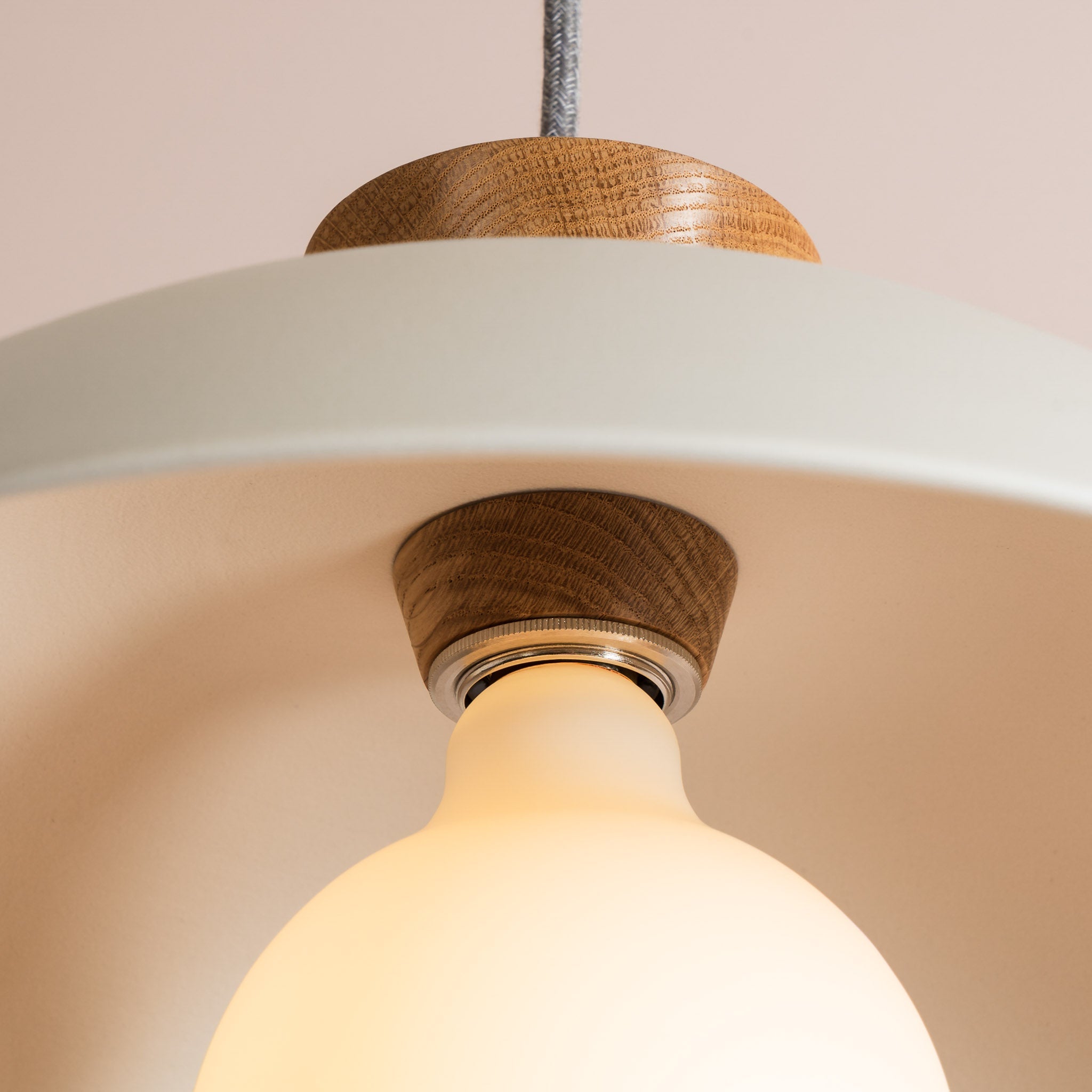 Close-up of a pendant light with wooden accents on a neutral background