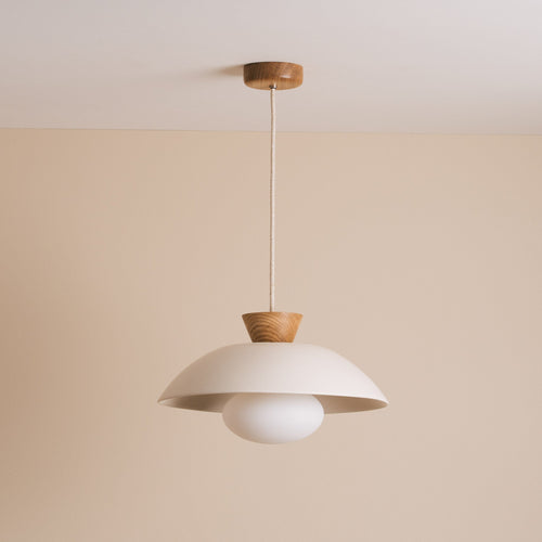 White ceramic pendant light hanging from oak ceiling rose against a cream wall